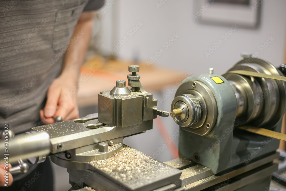 Mechanic is working at old lathe machine. Tool-machine that rotates a ...