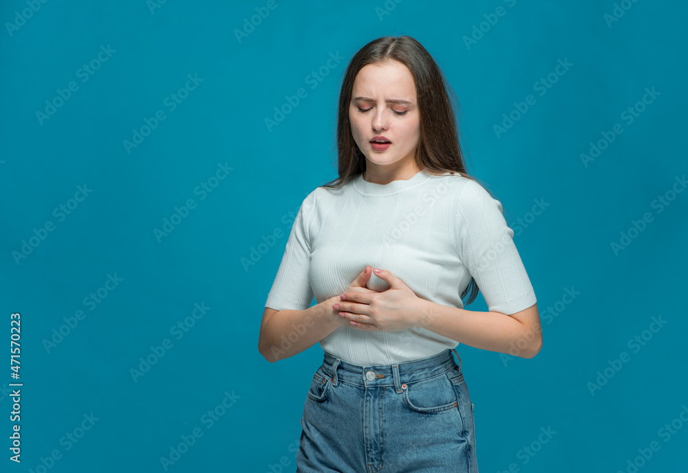 Ill young girl touching her ribs under breast, suffering intercostal