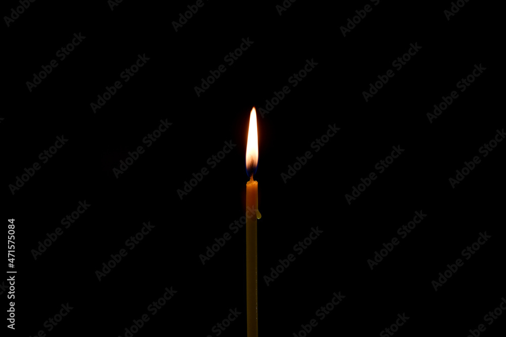 a candle burns in the dark on a black background. dripping drop of wax. a candle burns in the dark on a black background. dripping drop of wax.