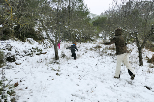 Φωτογραφία Mother, son and daughter playing in the snow