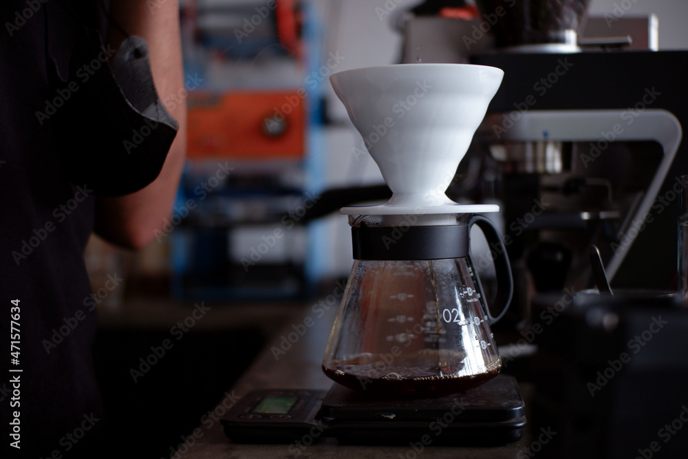 Barista Pouring Boiling Water From A Kettle Into A Drip Coffee Maker