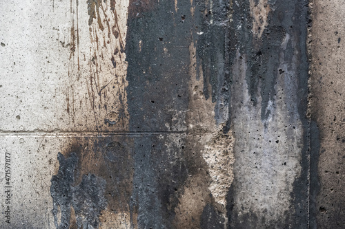 Soiled concrete wall by paint and fire residue, grunge background texture for social issues or architecture themes, copy space © Maren Winter