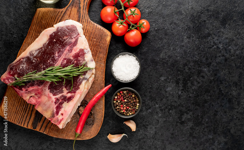 Raw t-bone steak with spices on a stone background. dry-aged steak with copy space for your text 