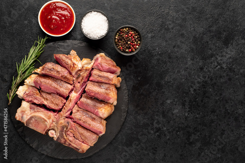 grilled t-bone steak with spices on a stone background  with copy space for your text