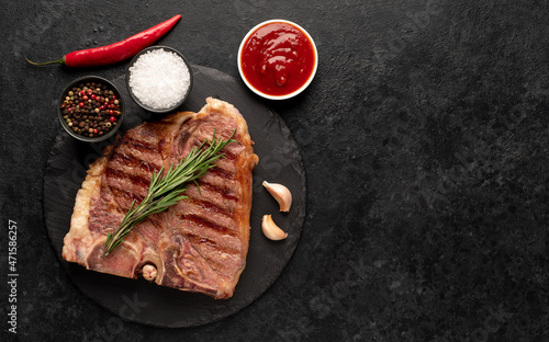 grilled t-bone steak with spices on a stone background with copy space for your text