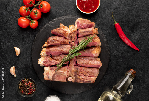 grilled t-bone steak with spices on a stone background