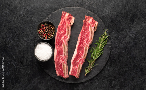 raw marbled beef ribs on stone background