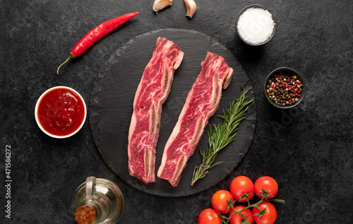 raw marbled beef ribs on stone background
