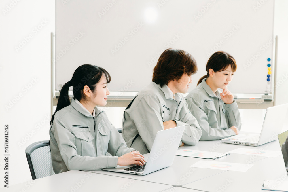 会議をする作業着をきた会社員(考える・3人)
会議をする作業着をきた会社員(考える・3人)
