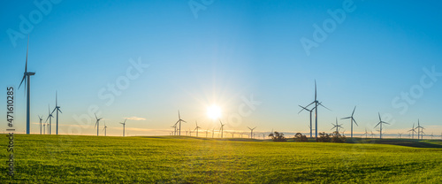 clean energy wind turbines on a green grass field