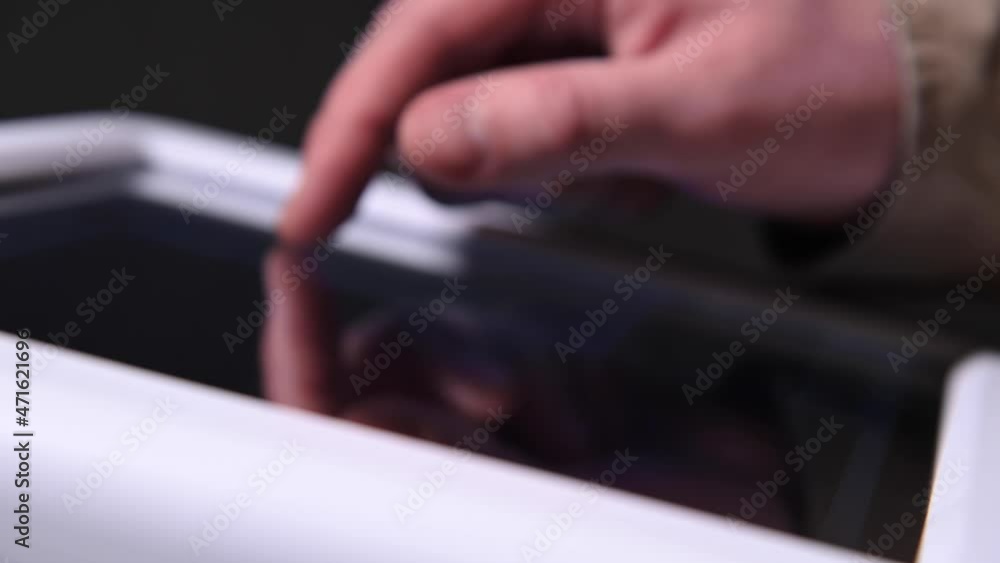 Close-up of a man's hand adjusting industrial technology on a touch screen in a dark production room. Live camera. Advertising production Close-up of a man's hand adjusting industrial technology on a touch screen in a dark production room. Live camera. Advertising production