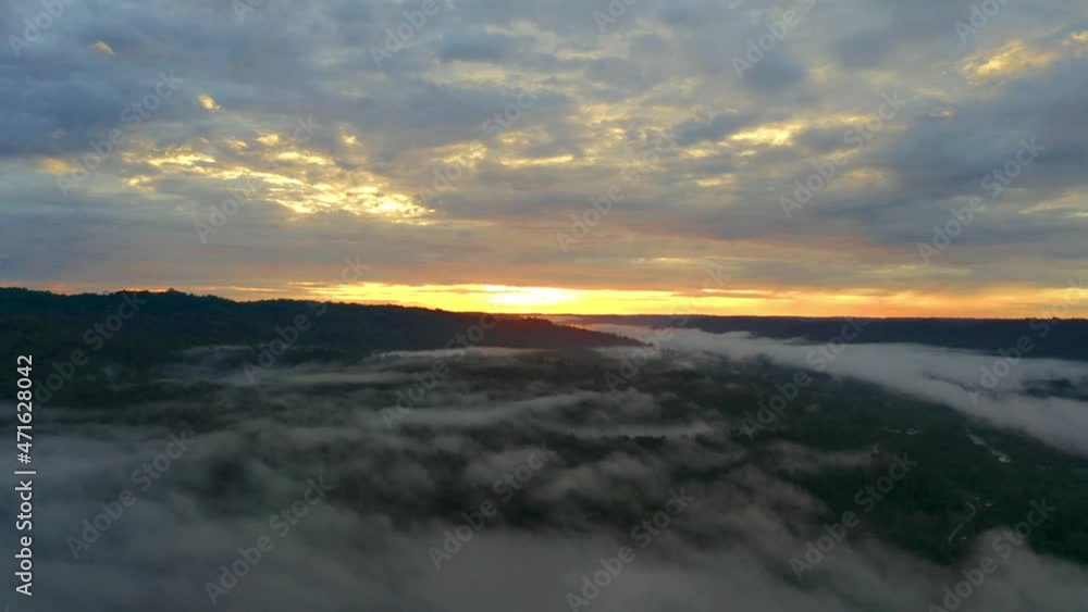 Aerial view over tropical forest during sunrise with a beautiful orange colored sky Aerial view over tropical forest during sunrise with a beautiful orange colored sky
