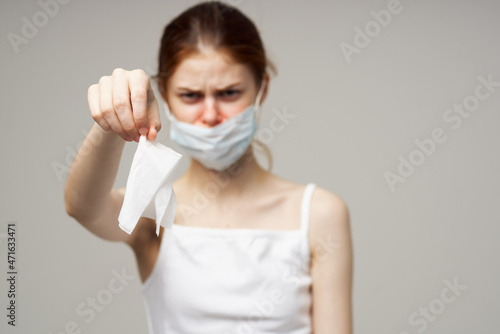 sick woman in white t-shirt with a scarf light background