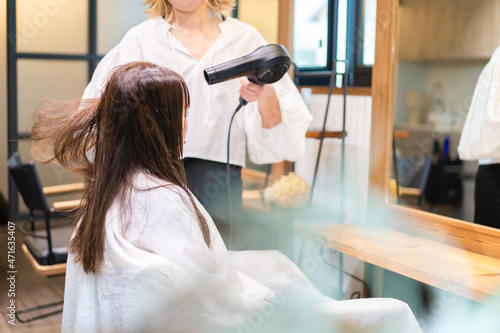 Fotografie ヘアドライヤーを使う美容師