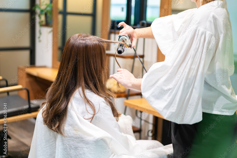 ヘアアイロンを使う美容師
