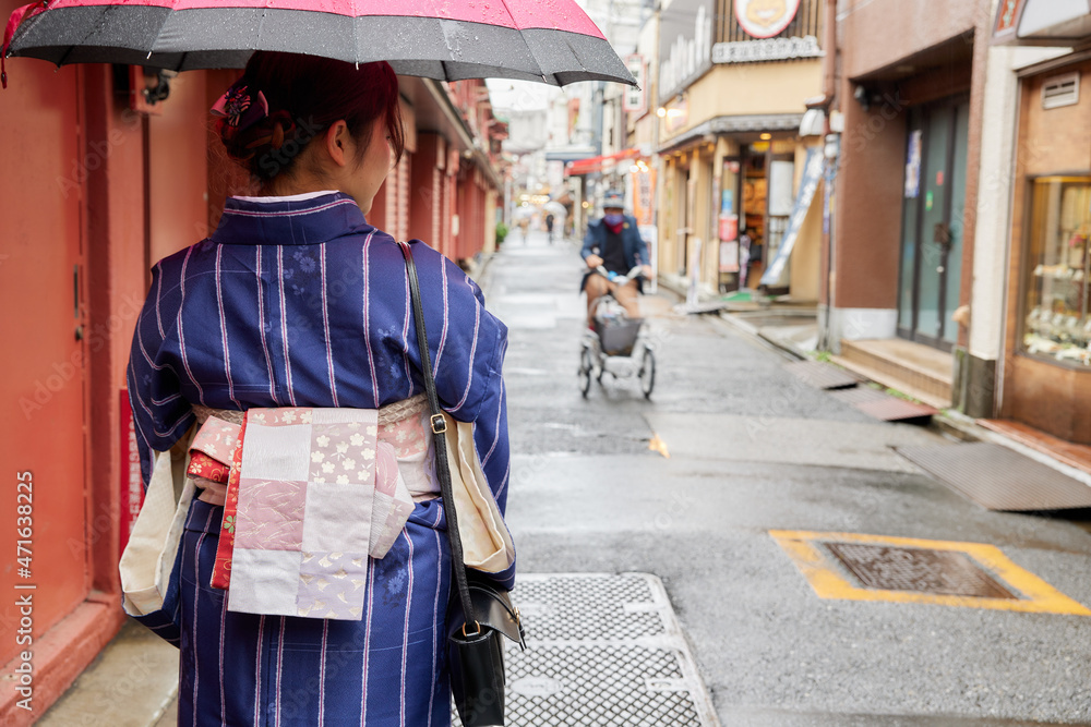 浅草の小道を歩く着物を着た日本人女性