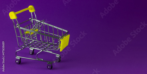 Shopping cart on a purple background. Copy space, business concept.