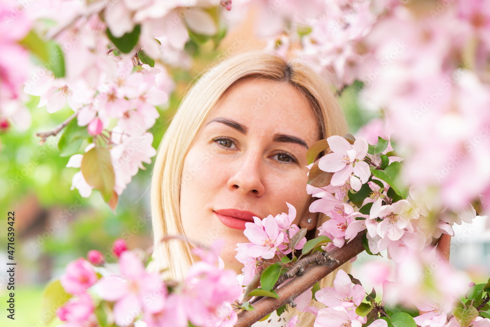 Young woman among the blossoming trees. Spring nature park or garden, flowering trees. Concept spring woman health Young woman among the blossoming trees. Spring nature park or garden, flowering trees. Concept spring woman health
