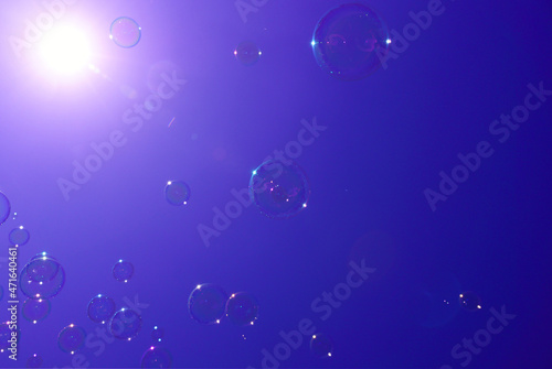 Beautiful, colorful, vivid and bright lilac, purple, violet or lavender background of bubbles or blisters and rays of white light from the corner