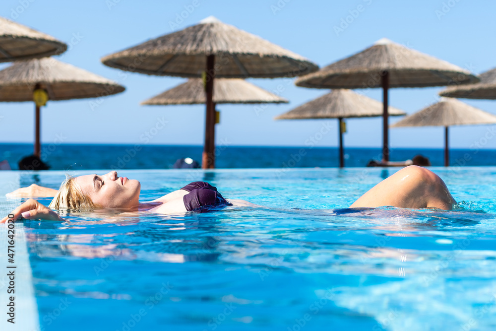 young attractive woman in in pool with head thrown