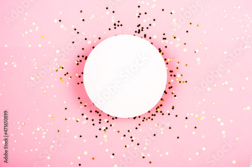 Golden stars sparkles confetti under white podium for cosmetics showcase on pink pastel trendy background.