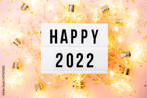 Happy New Year 2022 lletter board light box with christmas decorations and garland sparkling lights.CHristmas and holiday background photo