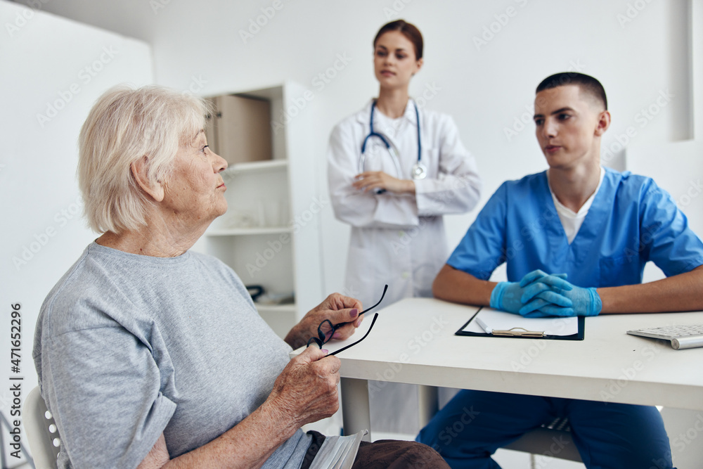 Obraz premium old woman at the doctor's and nurse's appointments in the medical office