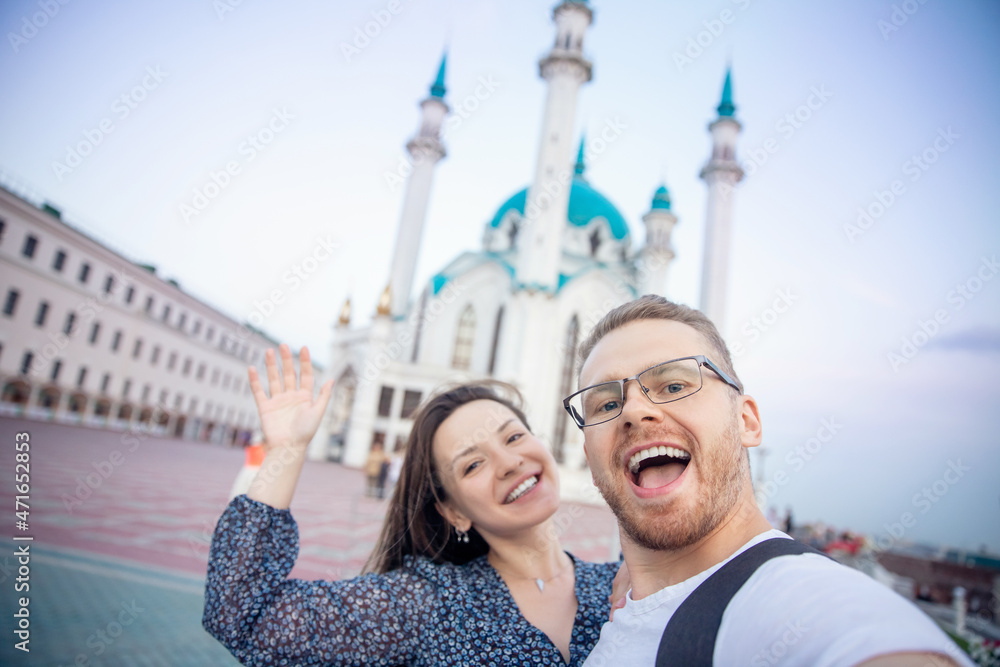 Couple tourist man and woman make selfie on background sunset Kul Sharif Mosque islam Kazan Kremlin. Concept tourism freedom muslim with religion
