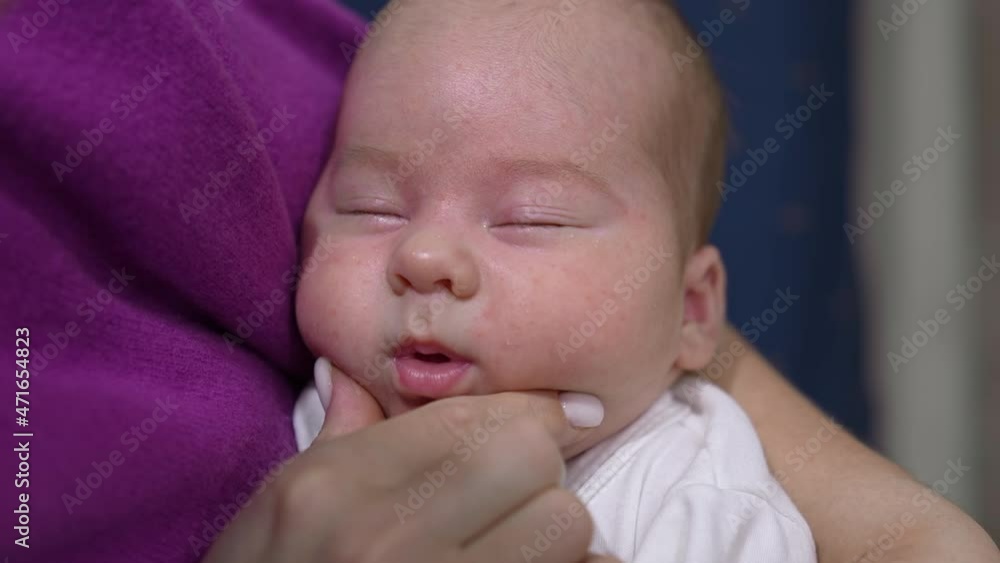 Face of an infant baby sleeping deeply and doesn’t want to wake up. Loving mum trying to wake her kid up and touches his sweet cheeks tenderly. Close up. Face of an infant baby sleeping deeply and doesn’t want to wake up. Loving mum trying to wake her kid up and touches his sweet cheeks tenderly. Close up.