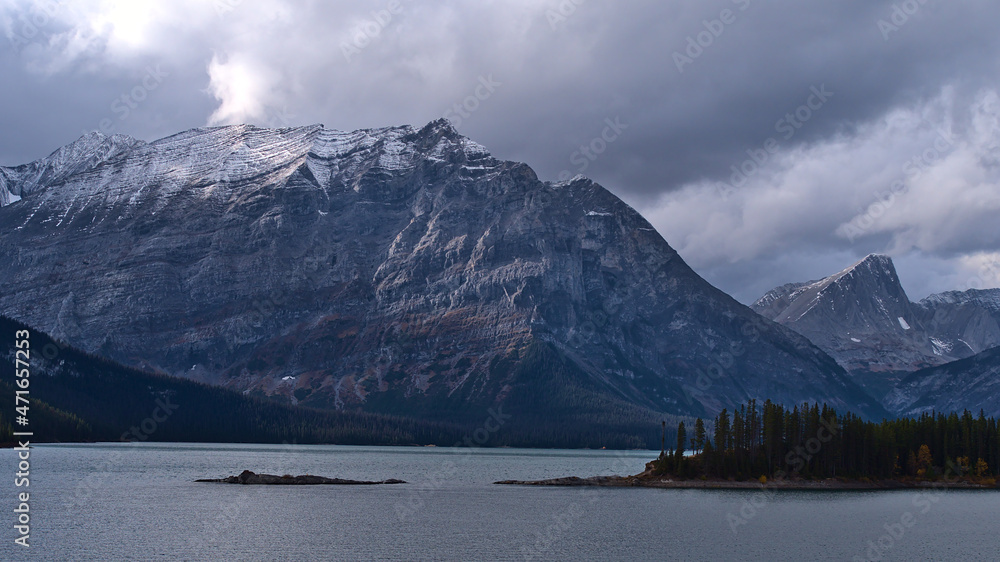 Beautiful panoramic view over reservoir Upper Kananaskis Lake in Alberta, Canada in the Rocky Mountains with forest on the rocky shore.