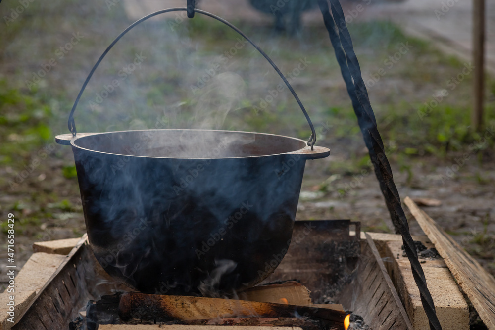 Hiking pot in the bonfire. Traveling in the mountains with tents Hiking pot in the bonfire. Traveling in the mountains with tents