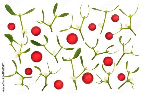 Christmas background with red ball baubles and mistletoe sprigs on white background. Abstract festive composition for the holiday season. Flat lay, top view. 