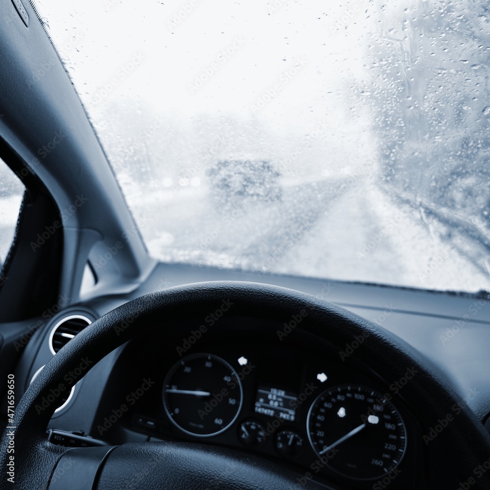 Dangerous winter season with snow on the road. The interior of the car from the driver's point of view - dangerous  traffic in bad weather.
