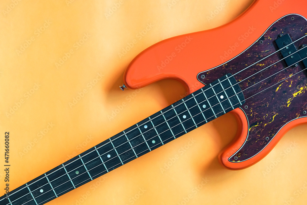 orange electric bass guitar on orange background with copy space orange electric bass guitar on orange background with copy space