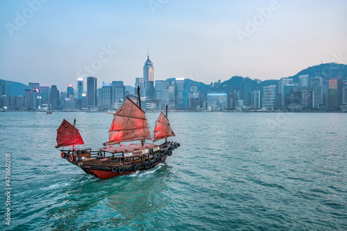 Junk boat with red sail at the Victoria Harbour in Hongkong, China photo