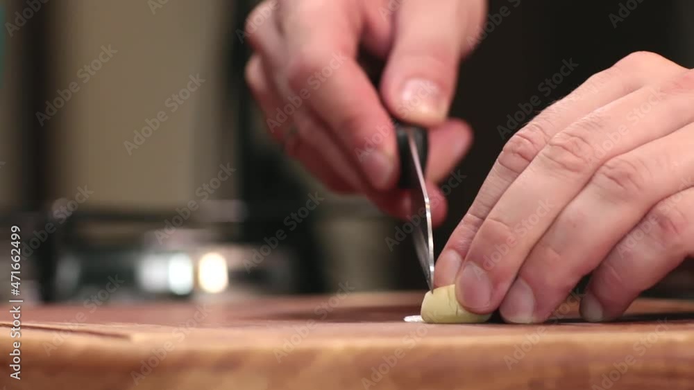 Chopping garlic on a wooden board for cooking. Chopping garlic on a wooden board for cooking.