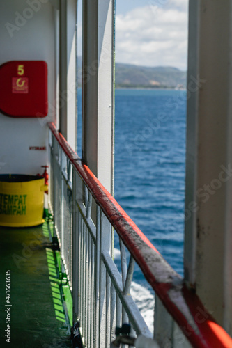 Railing of ferry in the side deck with a bay in the background