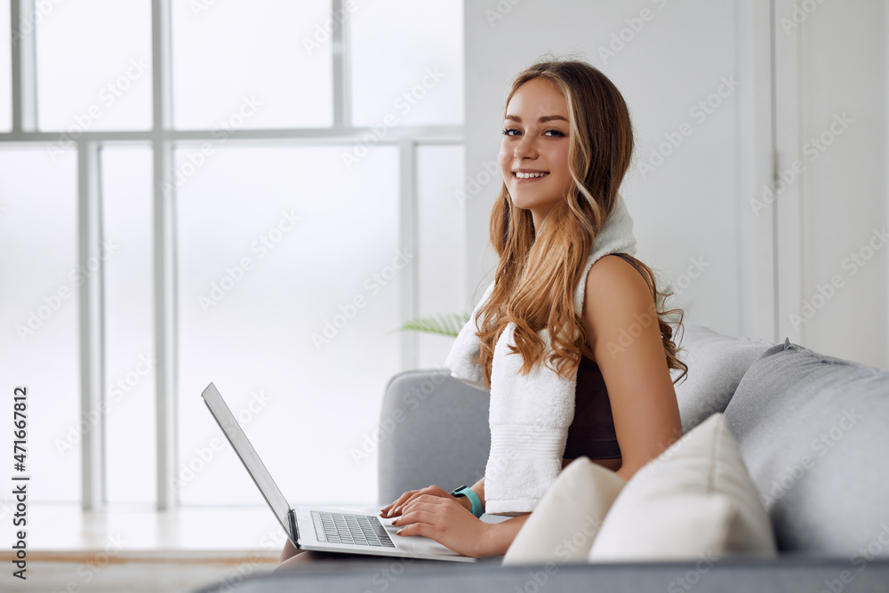 A smiling actress is smiling at the camera while typing something on her PC. A smiling actress is smiling at the camera while typing something on her PC.