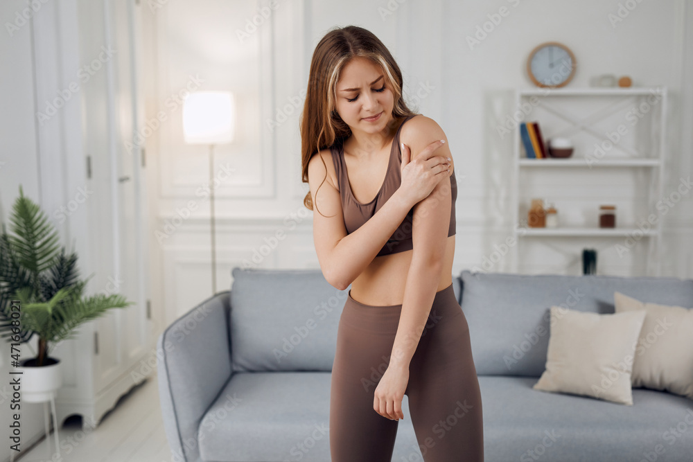 A yoga instructor is stretching her left hand with her right hand while looking concentrated. A yoga instructor is stretching her left hand with her right hand while looking concentrated.