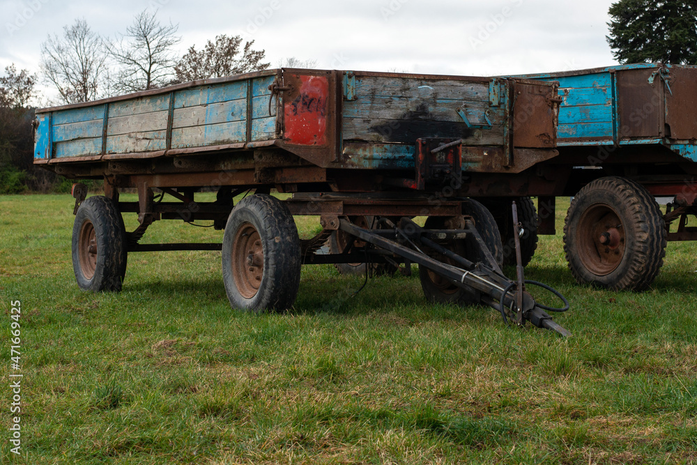 Fototapeta premium Old agricultural transport trailers in blue and red