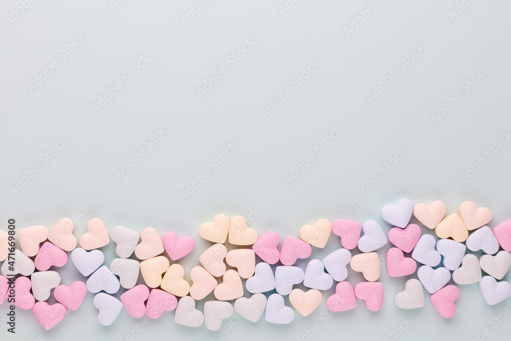 Composition with candy hearts on pastel blue background. Composition with candy hearts on pastel blue background.