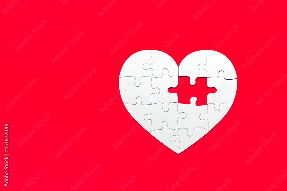 Puzzle pieces on red background. White heart puzzle pieces grid. Healthcare concept. Copy space for text, top view, close up. Puzzle pieces on red background. White heart puzzle pieces grid. Healthcare concept. Copy space for text, top view, close up.