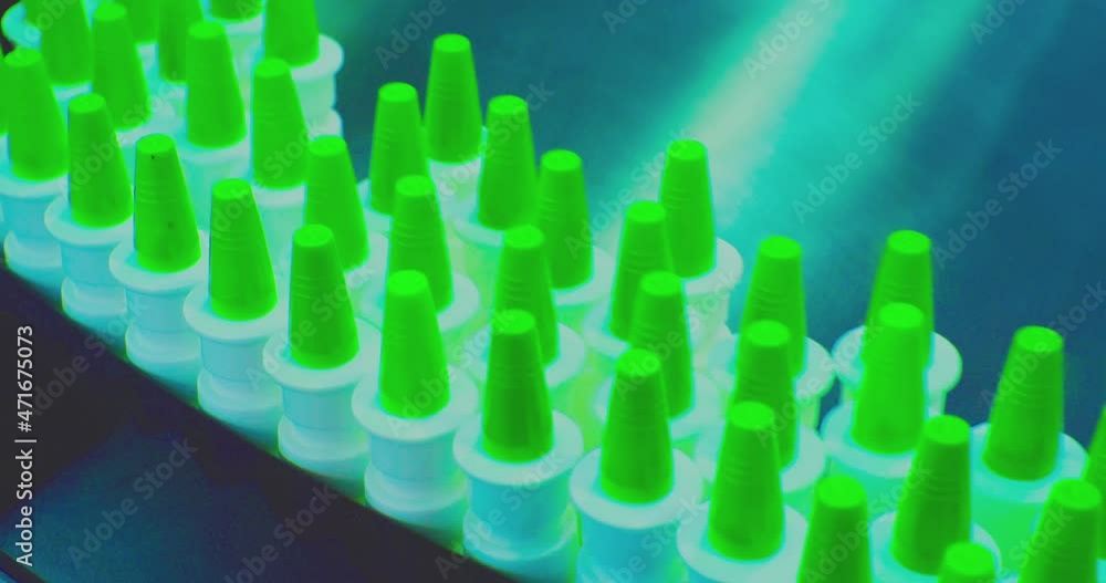 plastic vials of drugs are moving along the production line. close-up. plastic vials of drugs are moving along the production line. close-up.