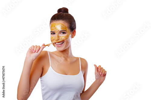 Beautiful Young Woman removes Anti-wrinkle and dull hair Mask, Moisturizes Skin with Collagen, Hyaluronic acid, 24k Gold and Vitamins. Isolated. Beauty and Care. White background  photo