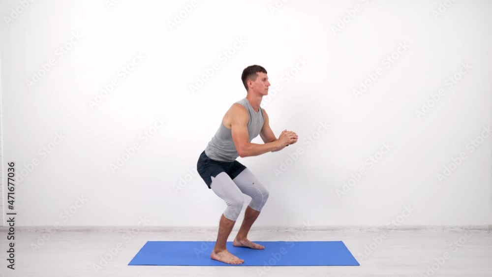 muscular man doing squats exercise on fitness mat white background, sport muscular man doing squats exercise on fitness mat white background, sport