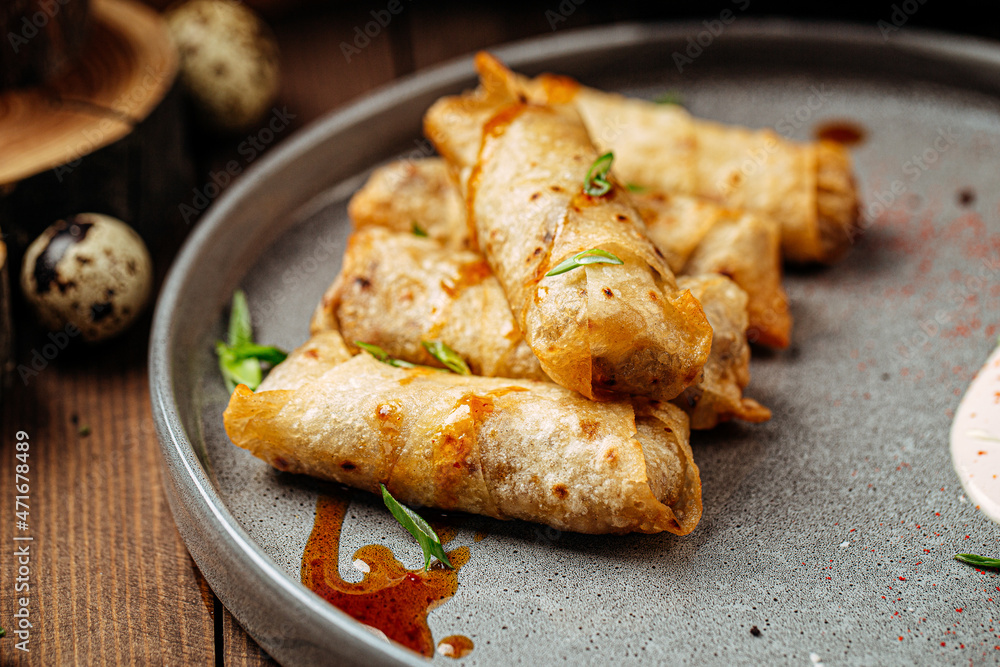 Turkish cigar shaped rolls boreks with sauce on wooden background Turkish cigar shaped rolls boreks with sauce on wooden background