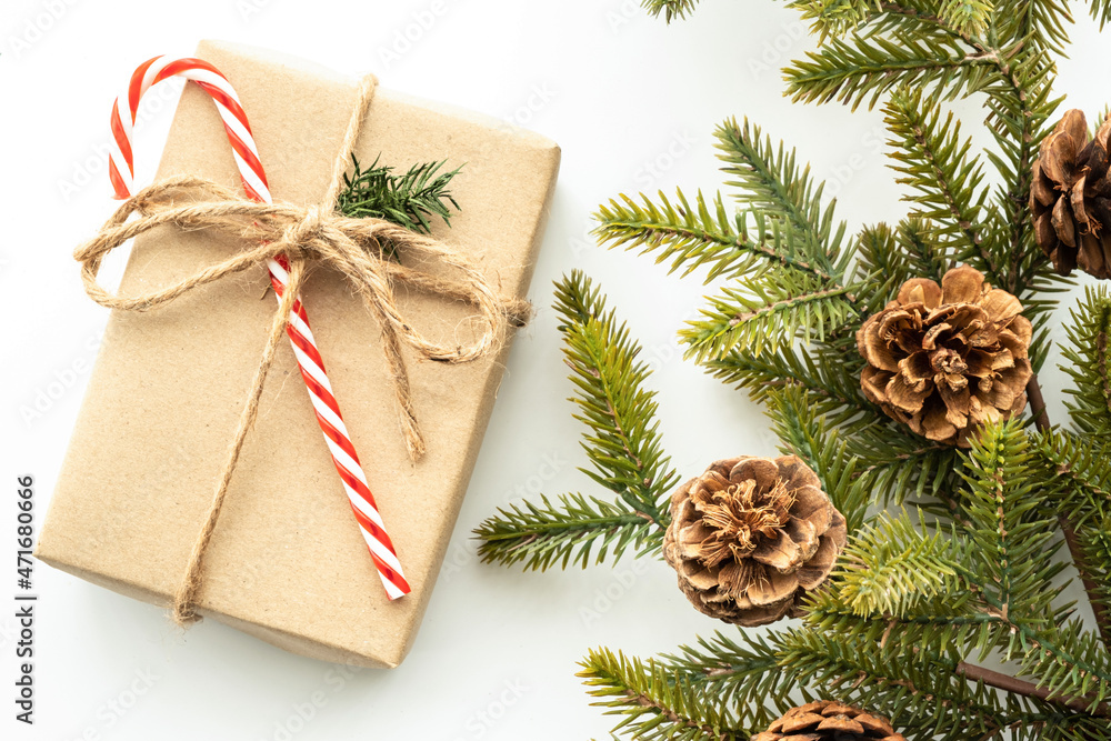 Beautiful Christmas background with gift box, decorate with pine branch and pine cone over white background. Top view with copy space, flay lay. Beautiful Christmas background with gift box, decorate with pine branch and pine cone over white background. Top view with copy space, flay lay.