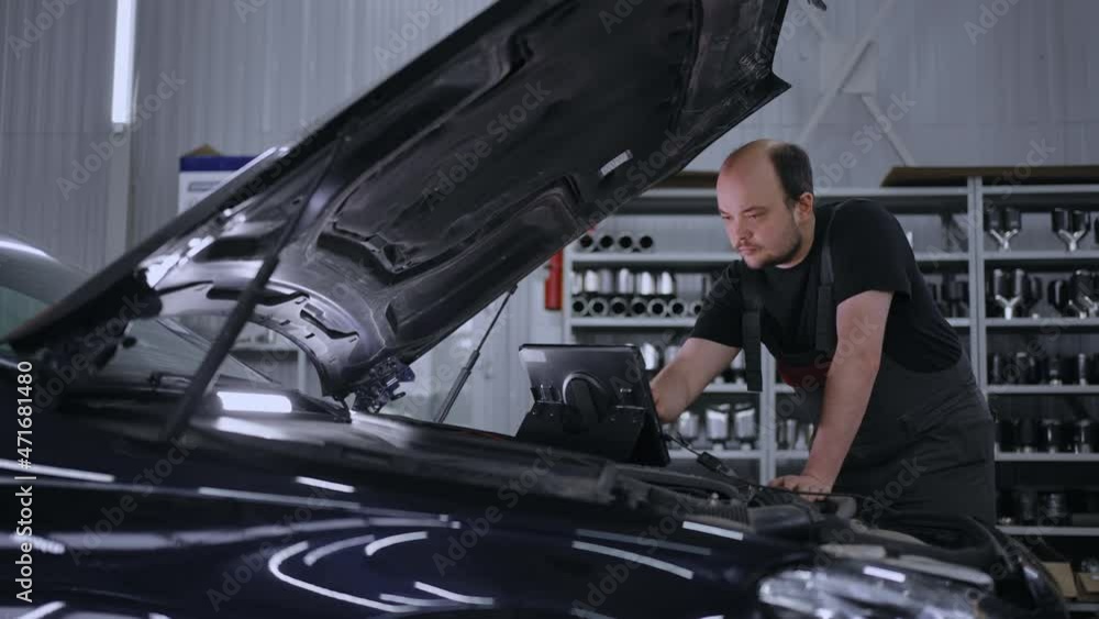 Using Digital Tablet For Car Diagnostic. mechanic using a tablet pc at the repair garage service. Interactive Diagnostics Software on an Advanced Computer. Using Digital Tablet For Car Diagnostic. mechanic using a tablet pc at the repair garage service. Interactive Diagnostics Software on an Advanced Computer.
