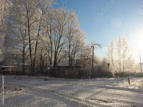 One winter frosty morning. An old abandoned house. Russian wooden traditional house. Trees covered with hoarfrost. Winter. Russia, Ural, Perm region.