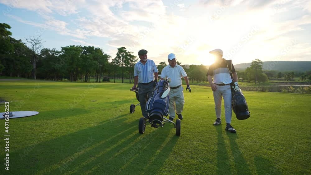 4K Group of Asian people businessman and senior CEO enjoy outdoor sport golfing together at country club. Healthy men golfer holding golf bag walking on fairway with talking together at summer sunset 4K Group of Asian people businessman and senior CEO enjoy outdoor sport golfing together at country club. Healthy men golfer holding golf bag walking on fairway with talking together at summer sunset